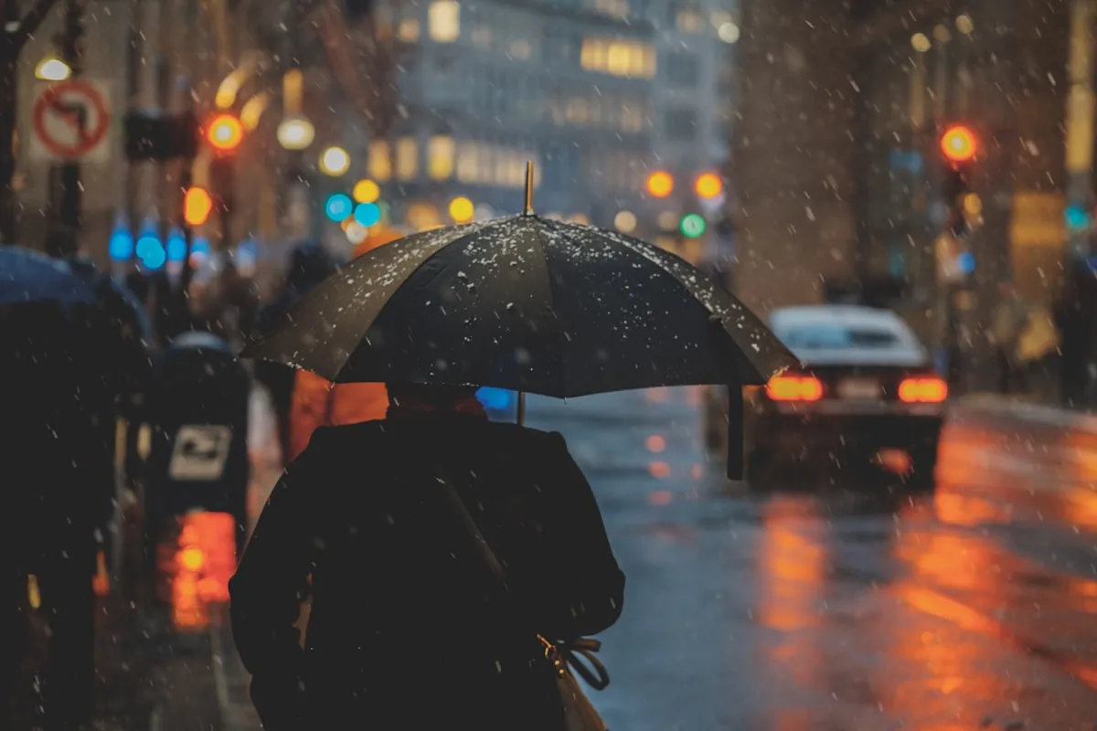 Person mit Regenschirm bei Regenwetter