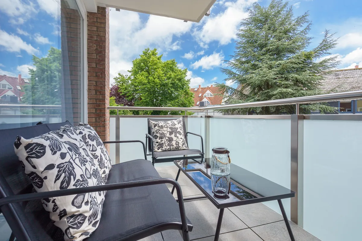 Sonniger Balkon der Fewo North East mit Sitzmöbeln und Blick ins Grüne
