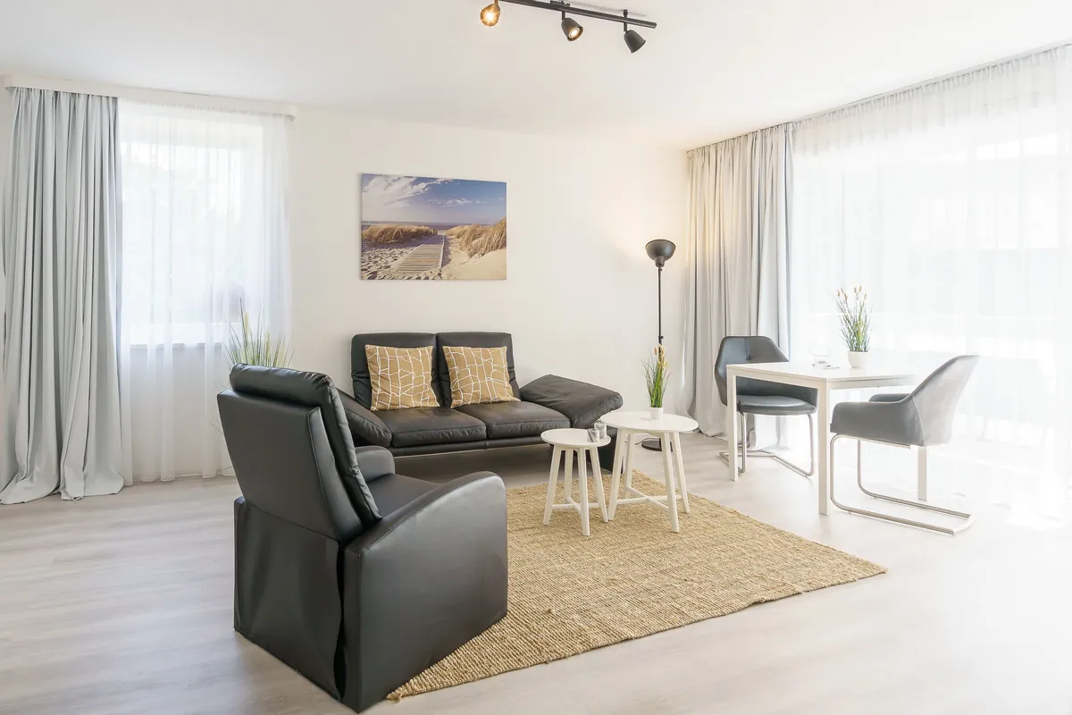 Wohnbereich der Fewo North East mit Sofa, Sesseln und Esstisch